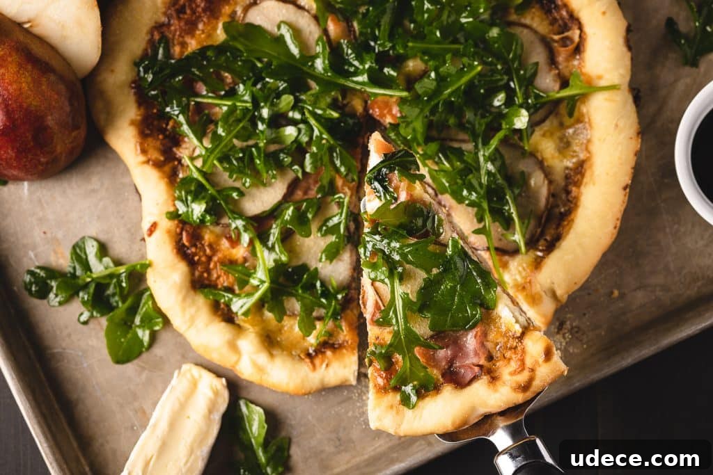 Dutch Oven Pizza with Pear, Brie & Prosciutto Recipe 6 Sliced Dutch oven pizza on a wooden cutting board.