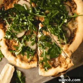 Dutch Oven Pizza with Pear, Brie & Prosciutto Recipe 7 Sliced Dutch oven pizza on a wooden cutting board.