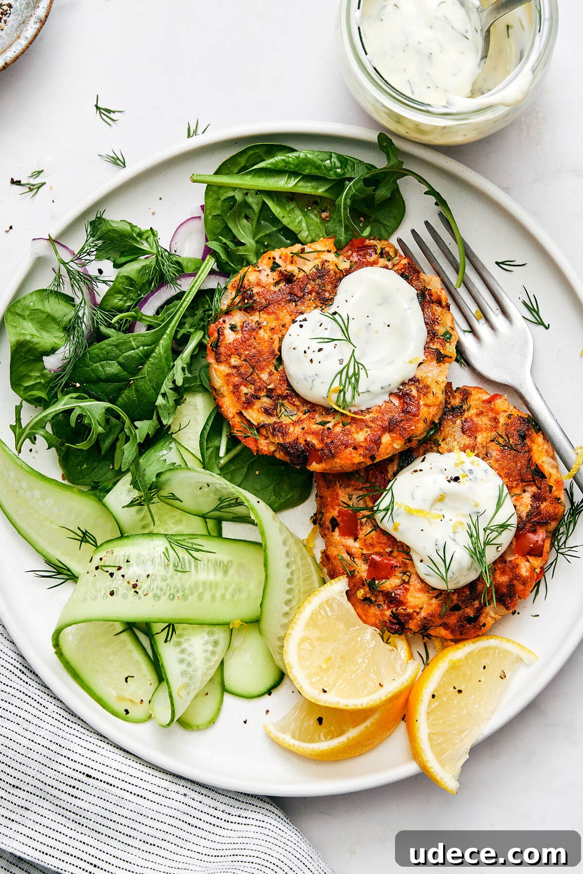 Salmon patties with a side salad on a plate.