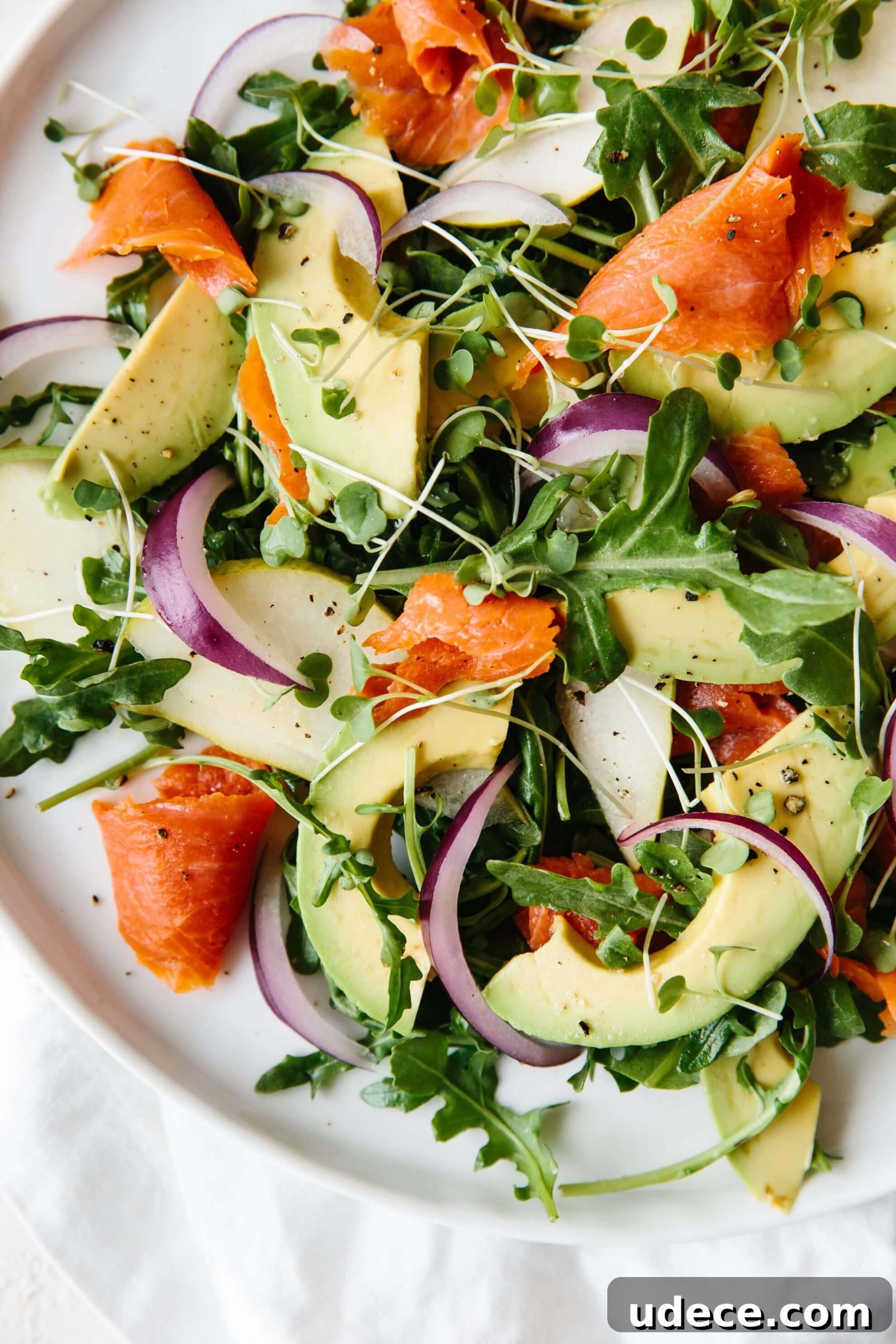 An easy and delicious arugula salad recipe made with baby arugula, smoked salmon, avocado, pear and red onion.