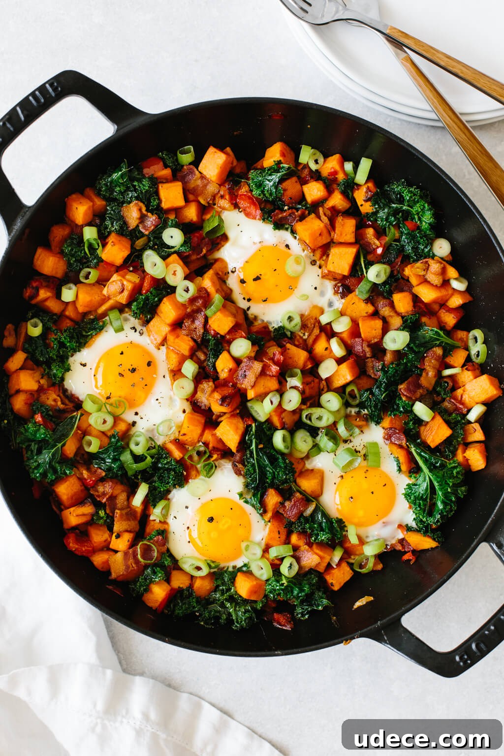 Cubed sweet potato and vegetables in a skillet with eggs.