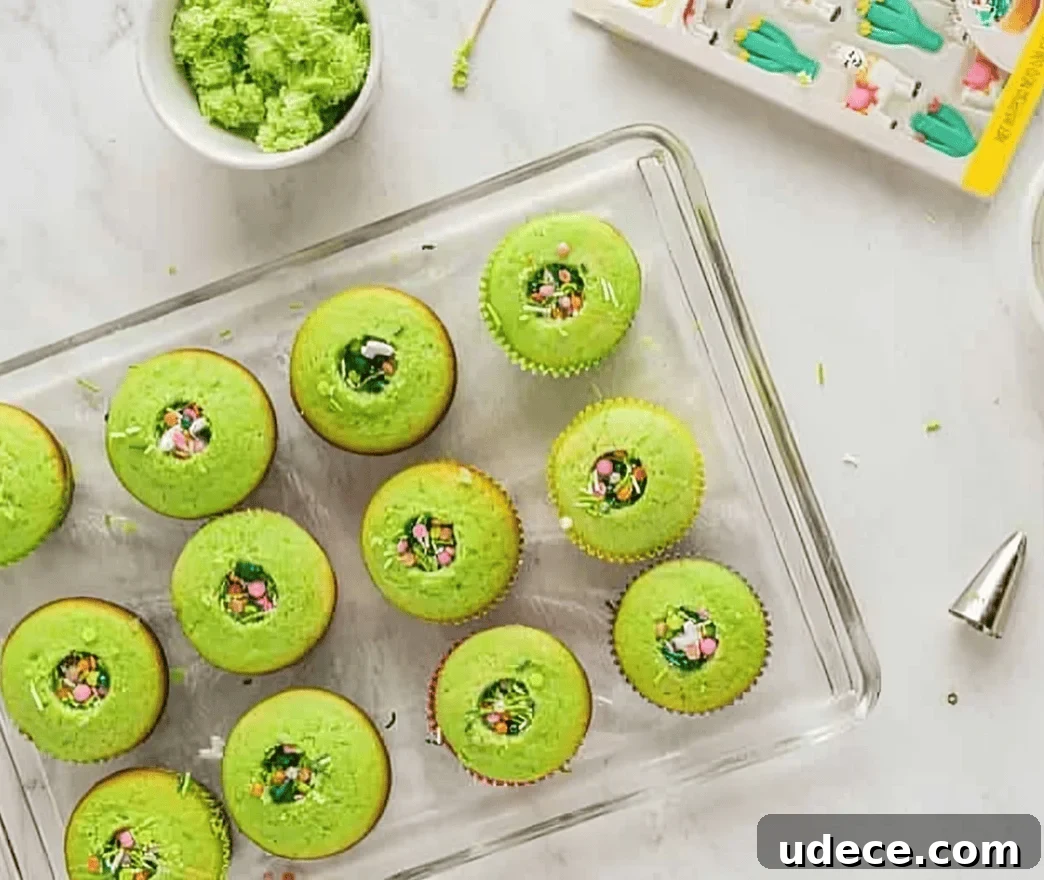 Festive Cinco de Mayo Cupcake Recipes and Decorating Ideas 9 cored green cupcakes with sprinkles in the center on a wire rack.