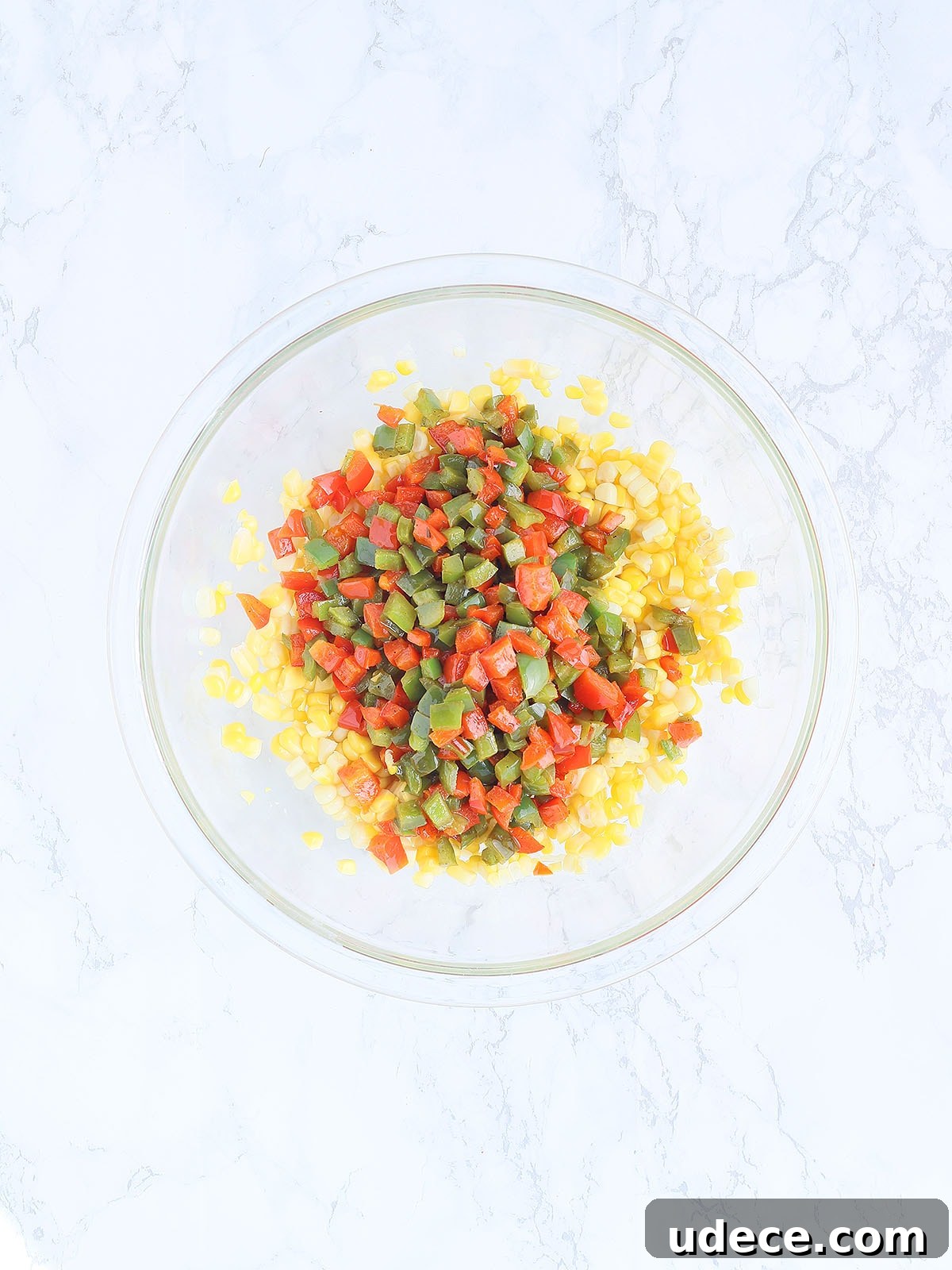 corn and sauteed diced bell peppers in a large blue skillet