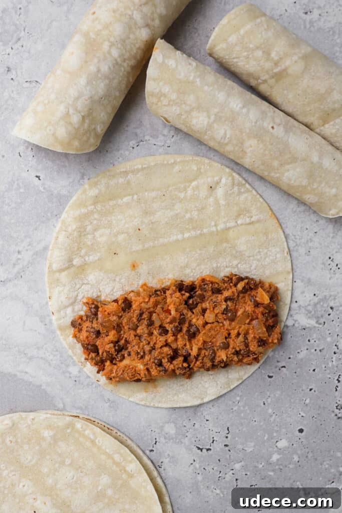 Vegan Lentil and Roasted Cauliflower Taquitos Recipe 5 how how to make the taquitos. Lentil cauliflower on side of the tortilla before being rolled up. Three pre rolled taquitos on the side.
