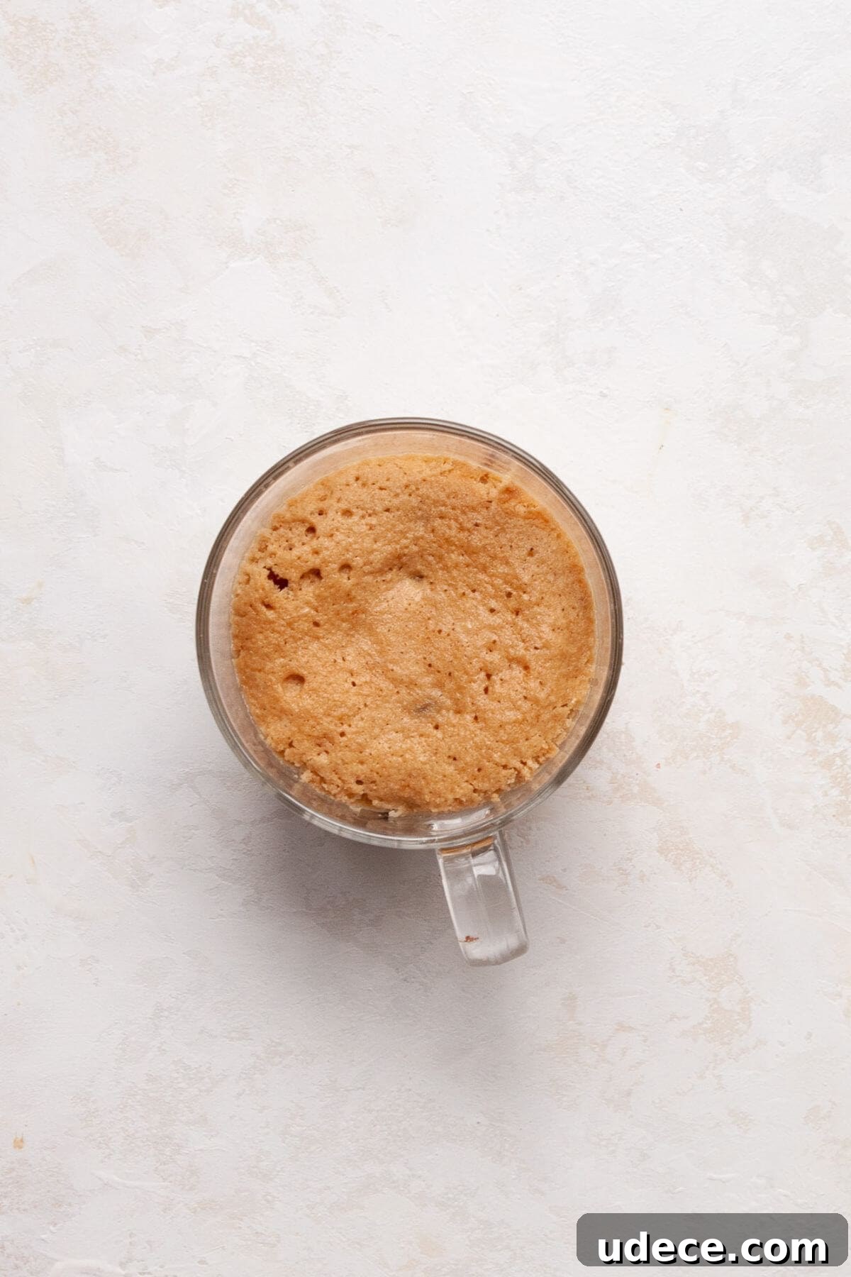 Protein Powder Mug Cake Recipe — Quick Single-Serve Dessert 6 Fluffy protein mug cake after cooking in the microwave for 60 seconds.