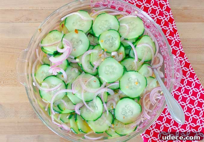 Tangy Pickled Cucumber & Red Onion Salad Recipe 5 Pickled Cucumber and Red Onion Salad in clear bowl on a red cloth