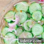 Tangy Pickled Cucumber & Red Onion Salad Recipe 7 Pickled Cucumber and Red Onion Salad in clear bowl on a red cloth