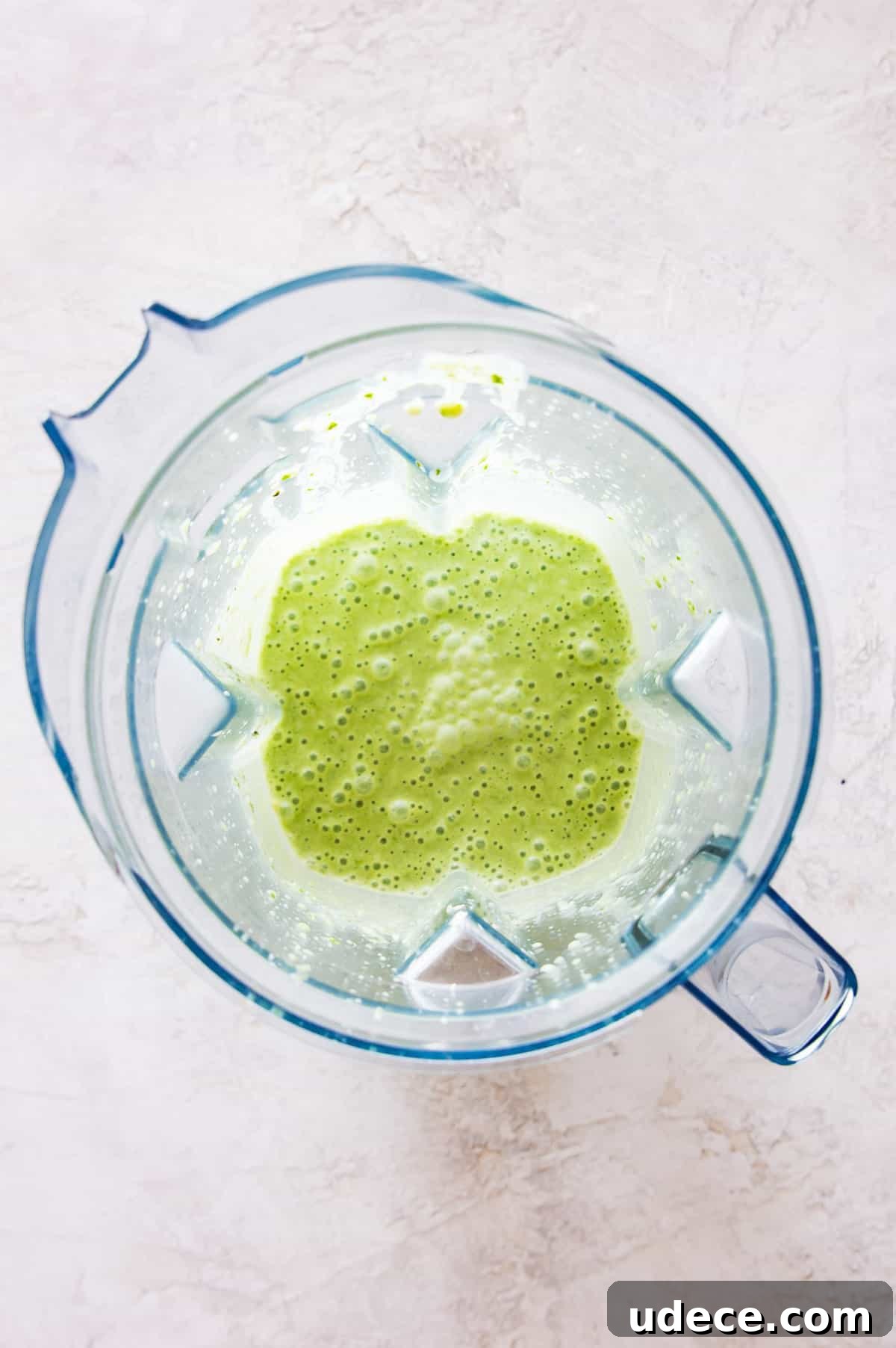 A blender with a green smoothie in it.
