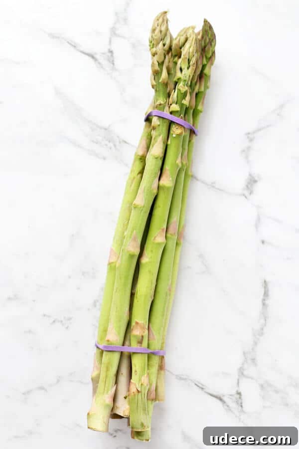 Roasted Lemon Garlic Asparagus Recipe for Crispy Tender Spears 3 a bunch of asparagus on a white marble background