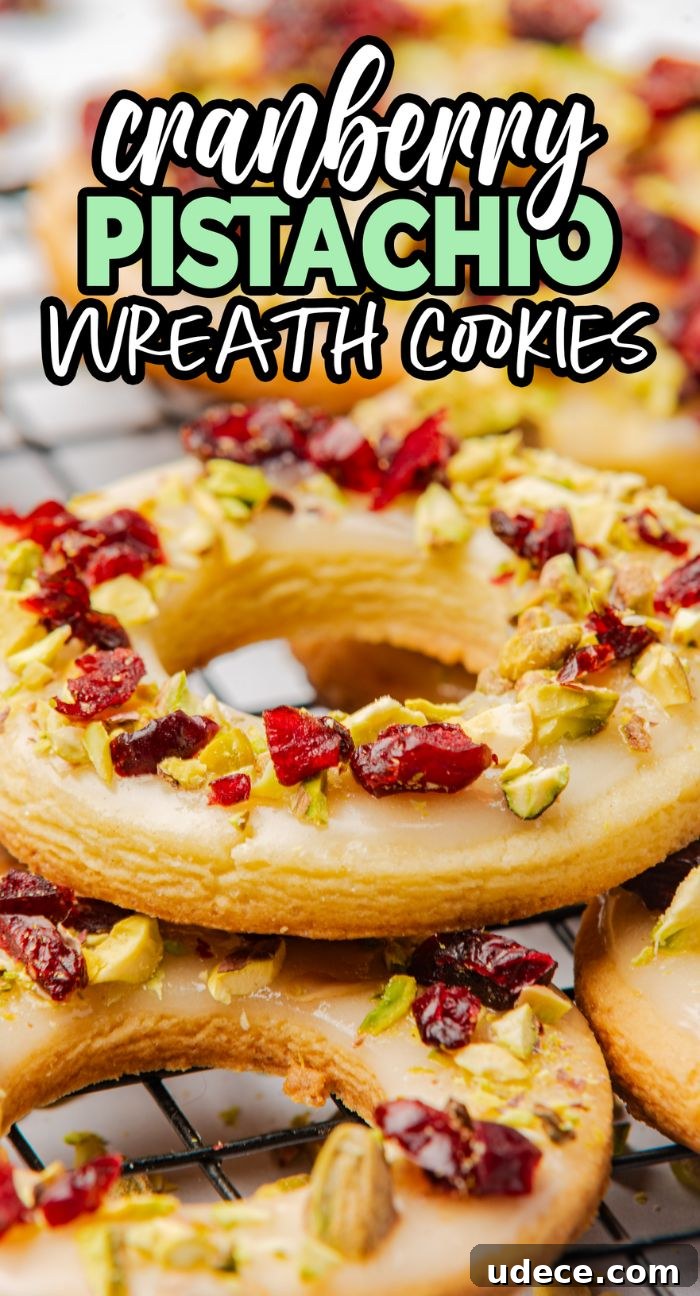 Cranberry Pistachio Holiday Wreath Cookies Recipe 13 Cranberry pistachio wreath cookies are round treats topped with white icing, chopped pistachios, and dried cranberries on a cooling rack.