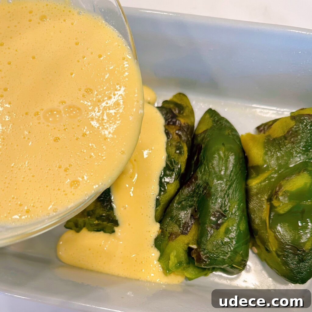Chili Relleno Casserole Recipe: Cheesy Roasted Poblanos Bake 11 Batter being poured over stuffed chili peppers.