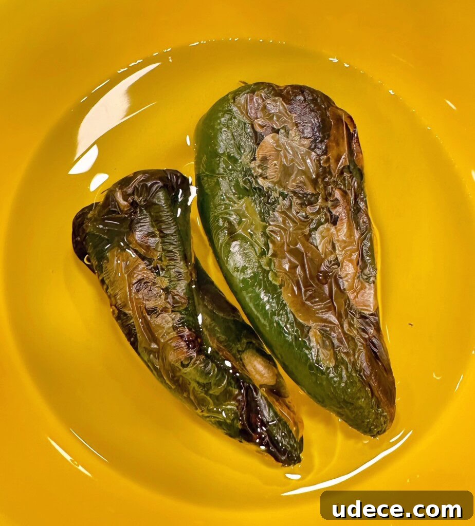 Chili Relleno Casserole Recipe: Cheesy Roasted Poblanos Bake 6 Roasted poblano peppers in water in a bowl.