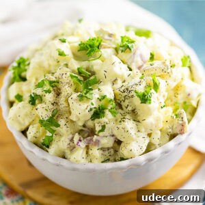 Classic Southern Potato Salad Recipe for Picnics and BBQs 4 Overhead view of a small bowl of southern potato salad topped with fresh parsley and dill.