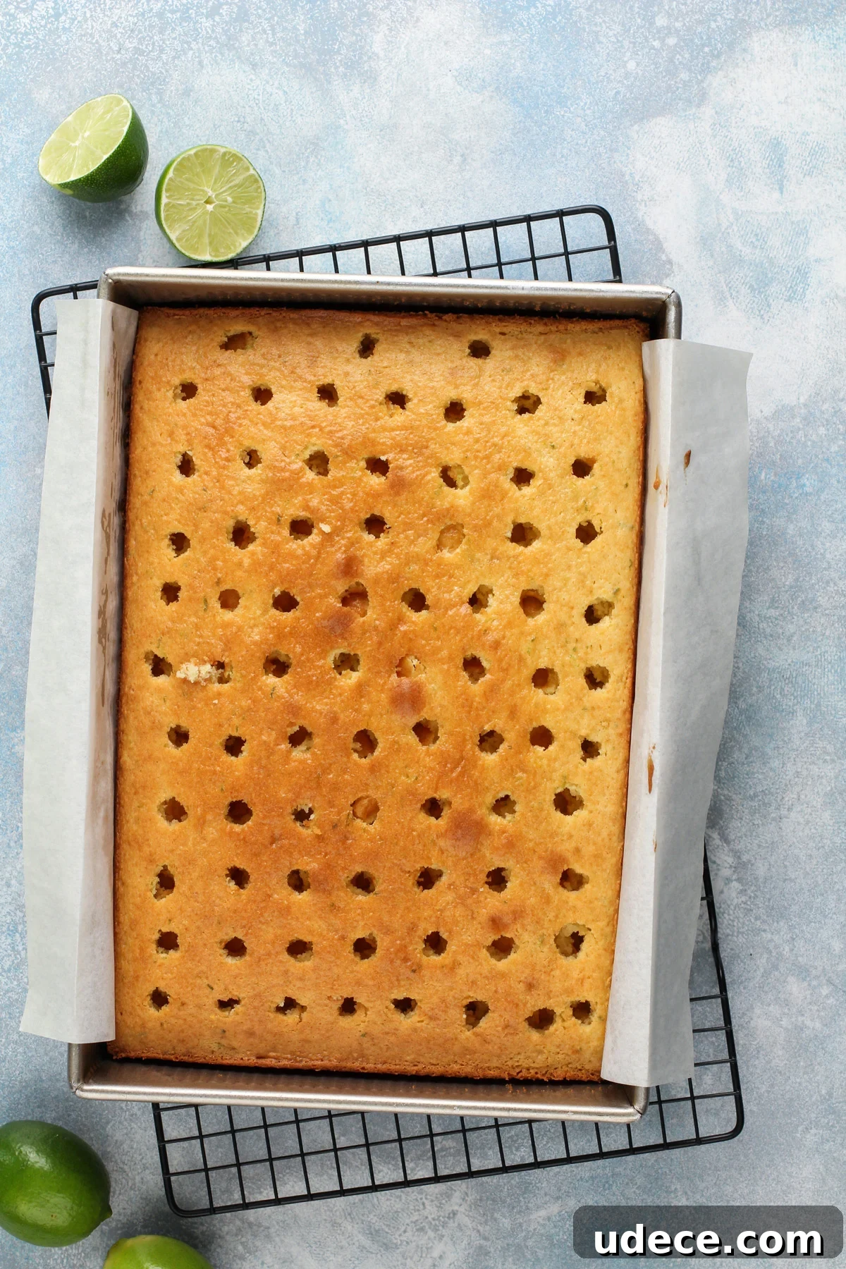 Baked vanilla cake with lime zest in a metal cake pan.