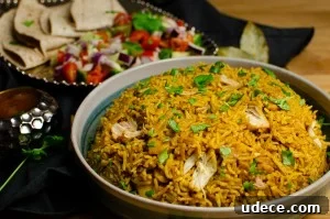 Authentic Pressure Cooker Chicken Biryani Recipe – Ready Fast 10 Pressure cooker Chicken Biryani served in a green bowl with chopped coriander on top, salad and mango chutney served on the side