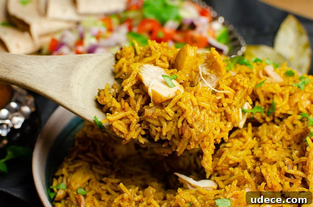 Authentic Pressure Cooker Chicken Biryani Recipe – Ready Fast 13 Chicken biryani being served up with a wooden spoon