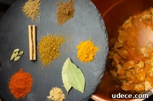 Authentic Pressure Cooker Chicken Biryani Recipe – Ready Fast 6 mix of paprika, cumin, allspice, ginger, turmeric and coriander. Plus a cinnamon stick & cardamom pods on a black slate