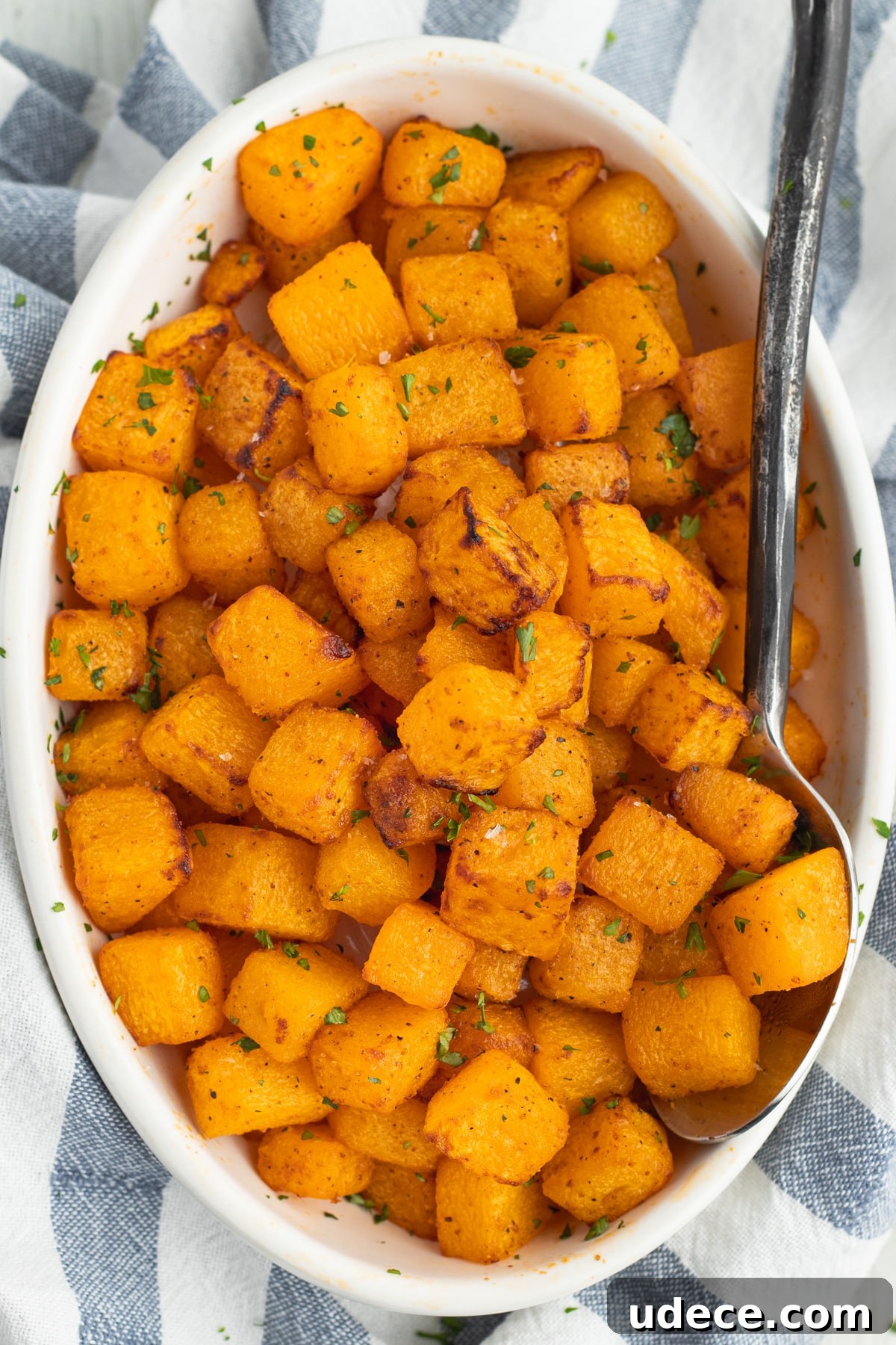 This is a picture of an oval dish filled with cooked butternut squash.
