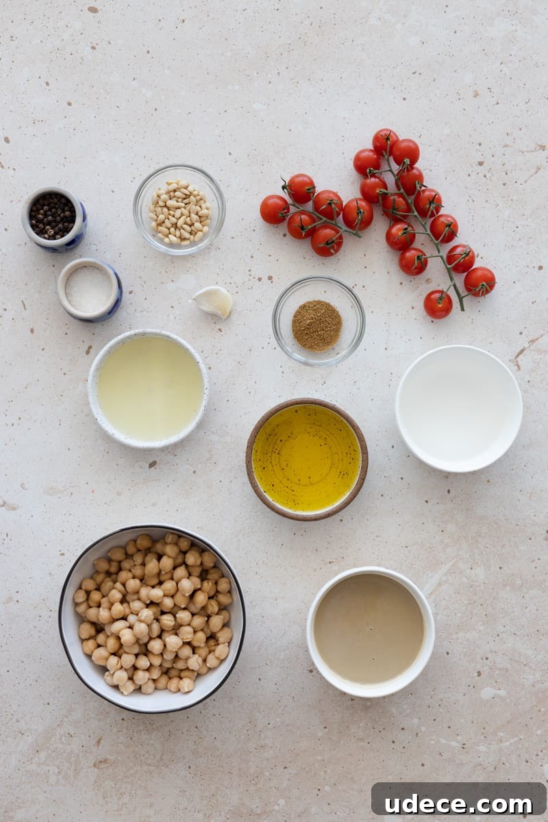 Ingredients for hummus with roasted vine tomatoes in small bowls.