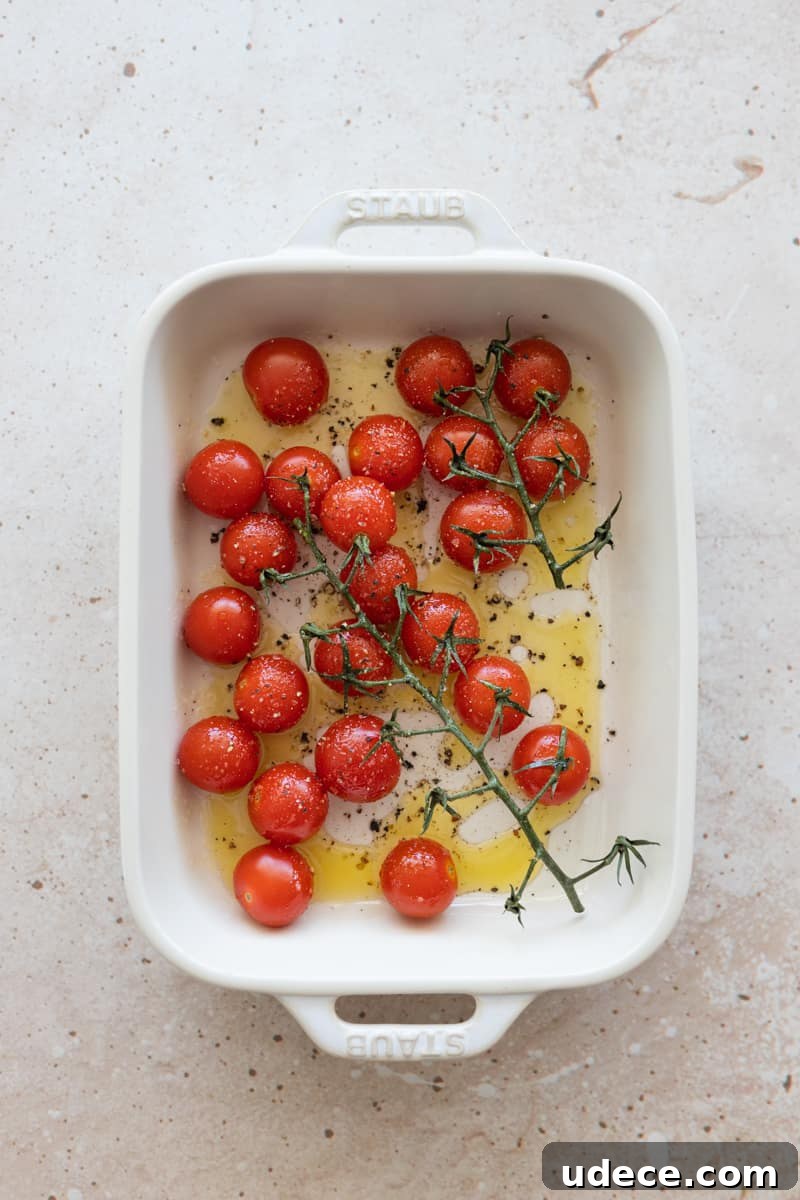 Tomatoes on the vine in a white baking dish.