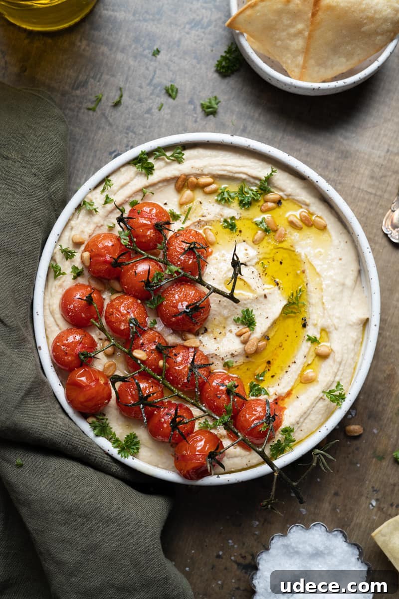 Hummus topped with roasted vine tomatoes, olive oil, pine nuts, salt and pepper.