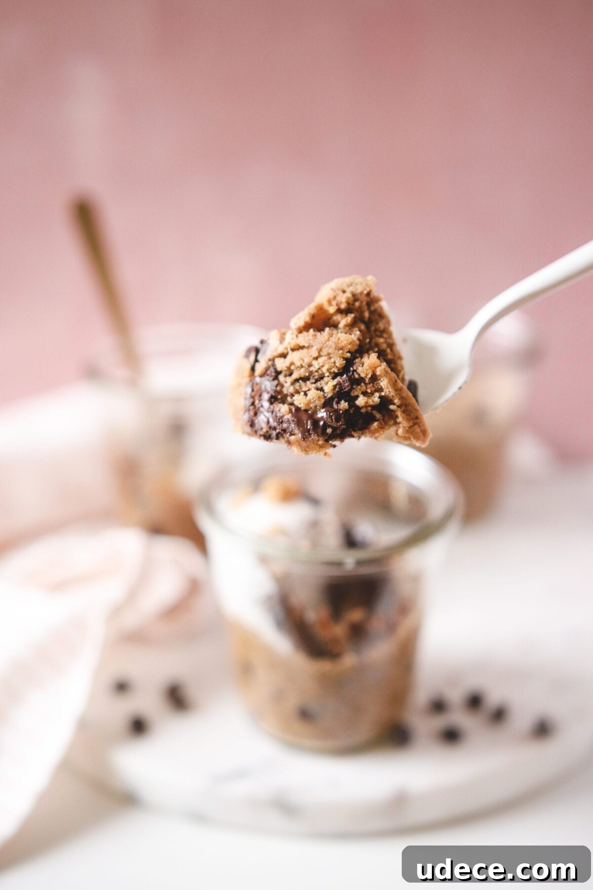 a bite resting on a spoon taken from chocolate chhip cookie jars