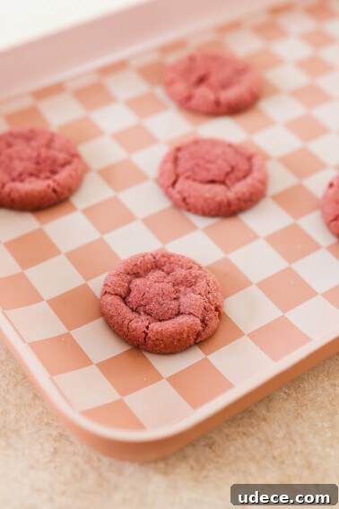 strawberry sugar cookies baked on a pink baking sheet