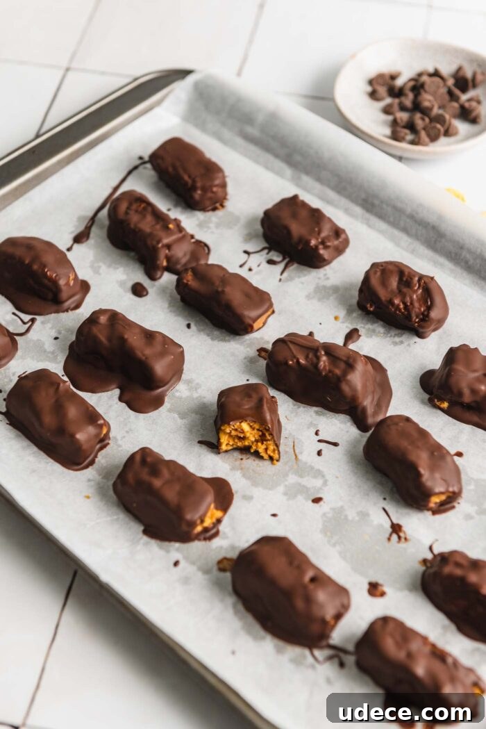 Homemade Butterfinger Candy Recipe Without Candy Corn 8 A baking sheet of homemade butterfinger candy bars. One bar has a bite out of it so you can see the texture inside.