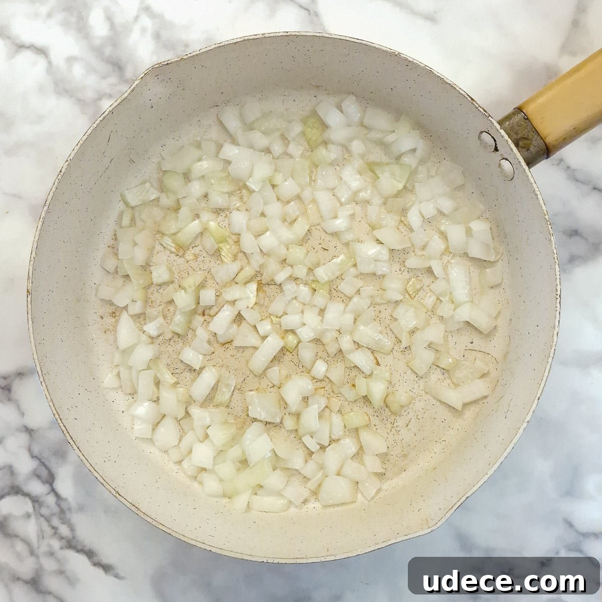 Chakalaka Recipe: Authentic South African Spicy Vegetable Relish 5 Step 1, onions frying in a pan.