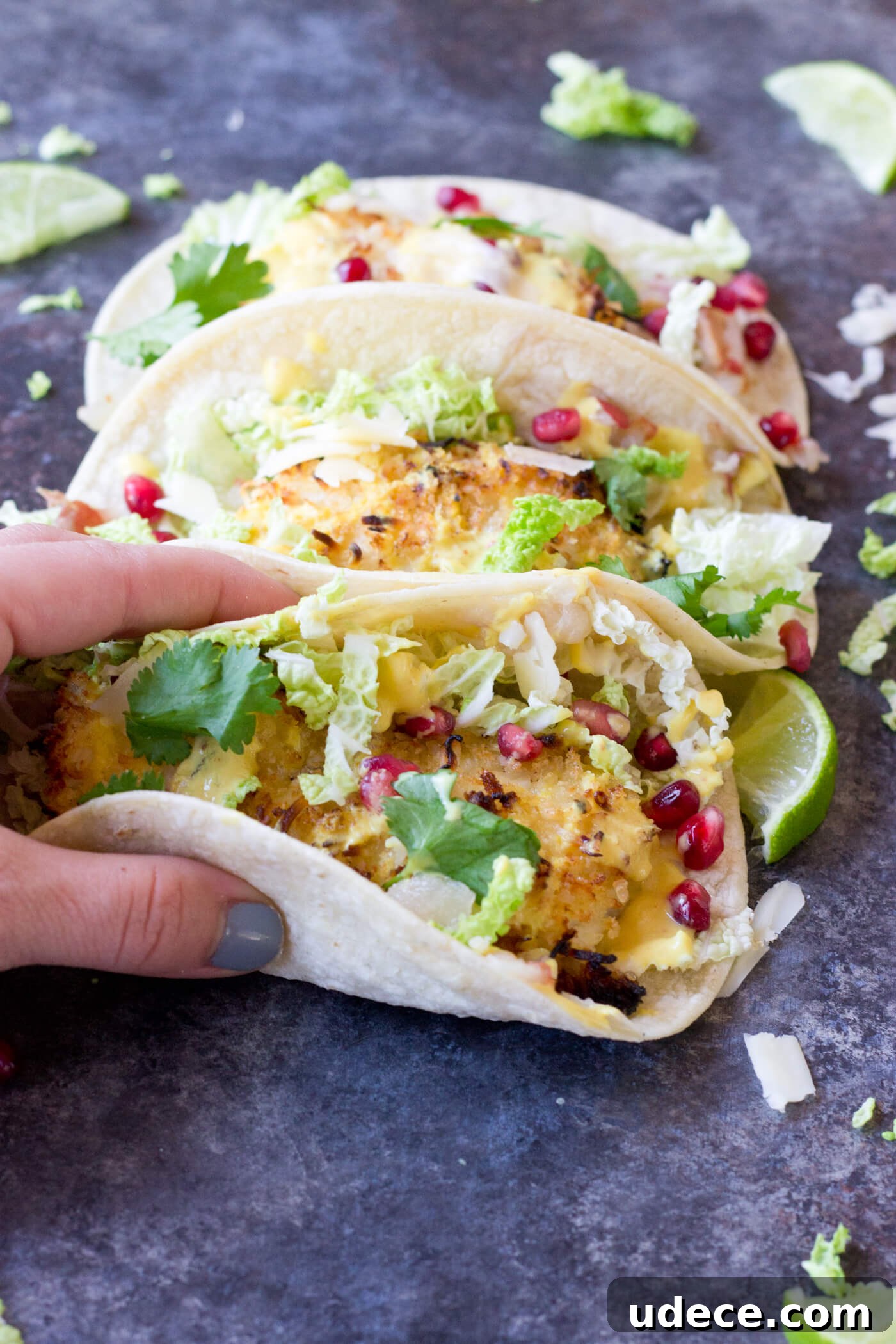 Crazy for tacos? Add these Crispy Fish Tacos to your menu! Crispy baked cod topped with pomegranates, shredded pear, and Honey Lime Crema. Simple to make at home!