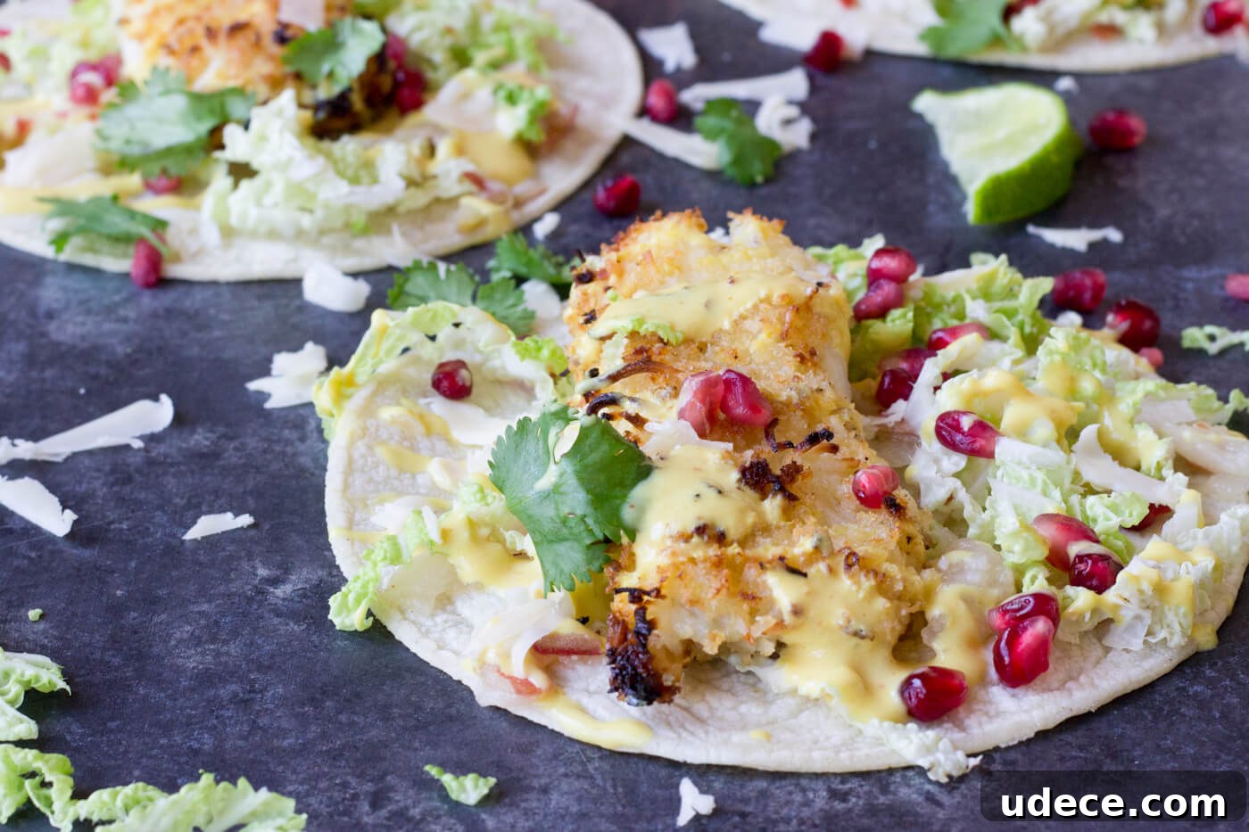 Crazy for tacos? Add these Crispy Fish Tacos to your menu! Crispy baked cod topped with pomegranates, shredded pear, and Honey Lime Crema. Simple to make at home!