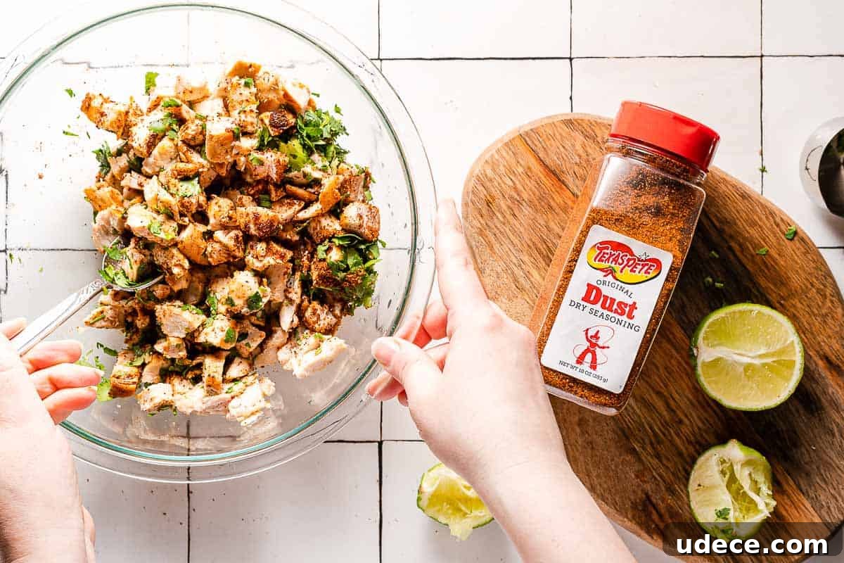 Spicy Queso Chicken Nachos Recipe for Game Night 4 spoon stirring chicken with herbs and spices