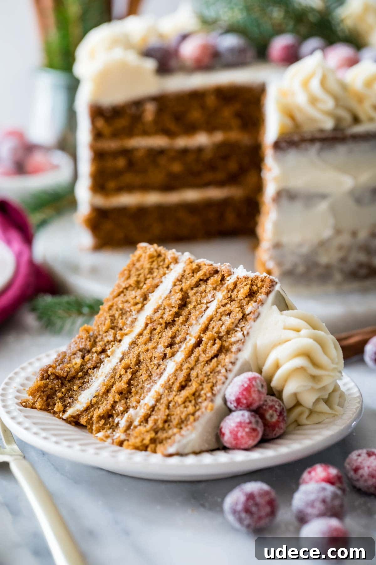 Gingerbread Layer Cake Recipe with Spiced Cream Cheese Frosting 2 Slice of gingerbread cake cut from a three layer cake in the background.