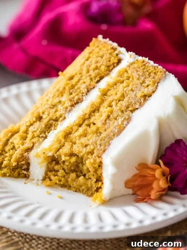 Gingerbread Layer Cake Recipe with Spiced Cream Cheese Frosting 12 Slice of pumpkin cake frosted with cream cheese frosting on a white plate.