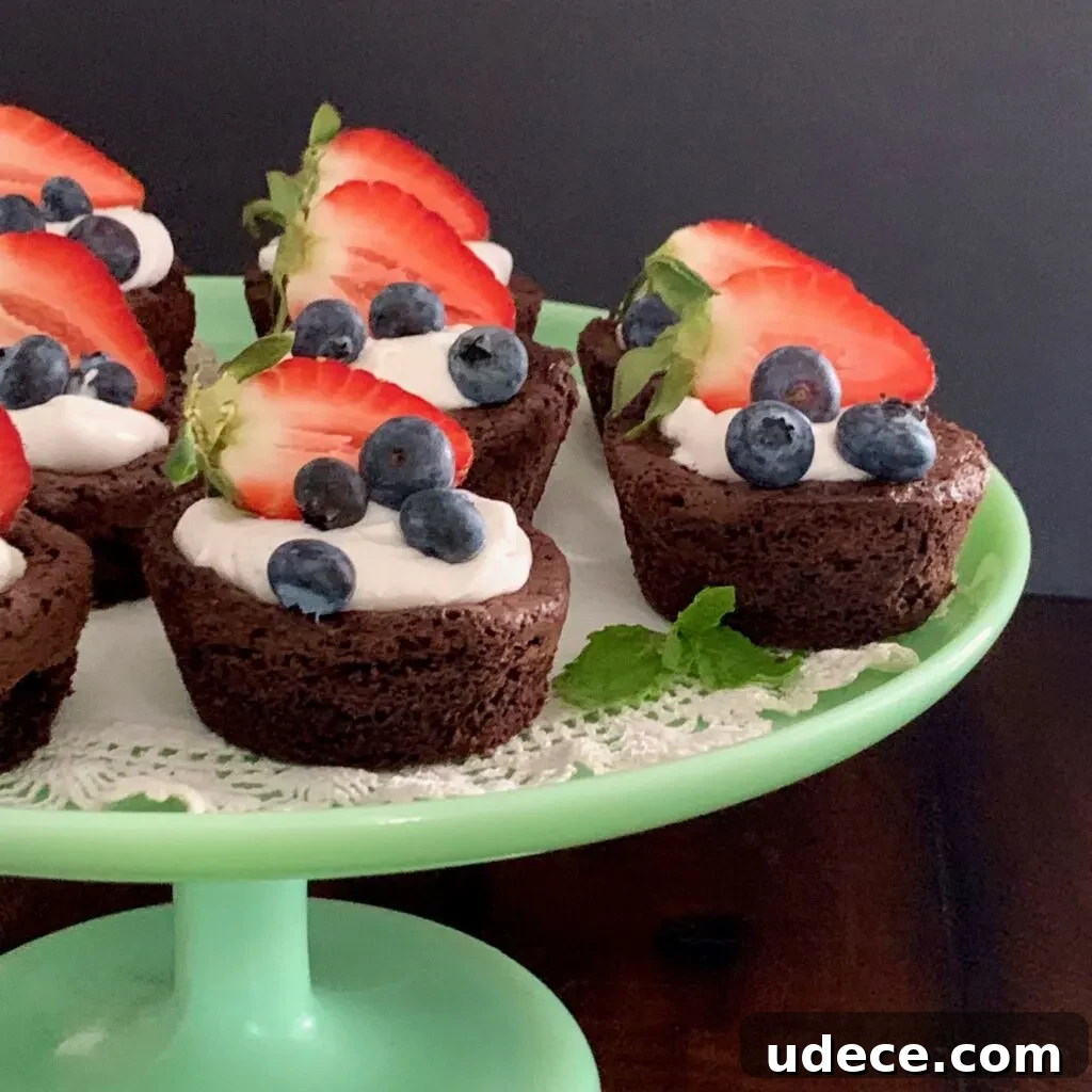 Mini Homemade Brownie Bites Recipe for Decadent Snackable Treats 3 Homemade brownie bites on a serving tray topped with dairy free whipped topping and fruit.