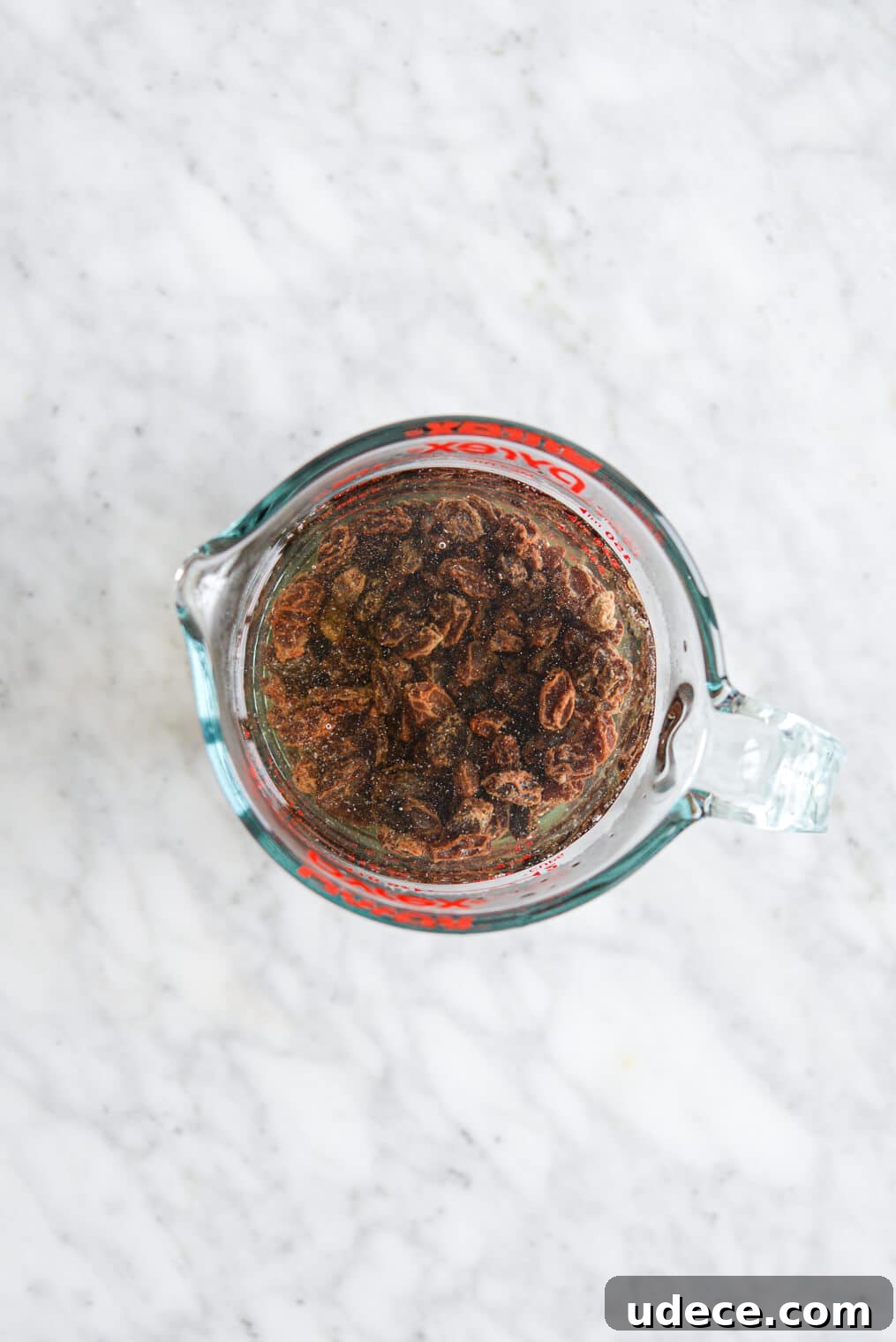 Raisins soaking Glass pyrex measuring cup with raisins soaking in water.
