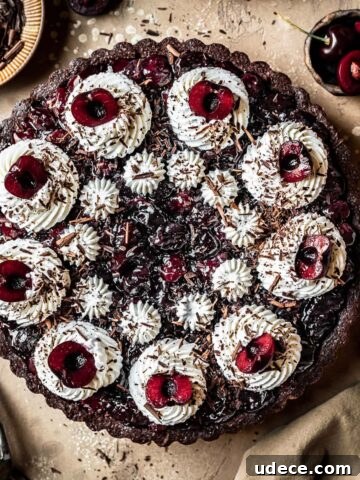 A chocolate cherry tart with piped whipped cream swirls