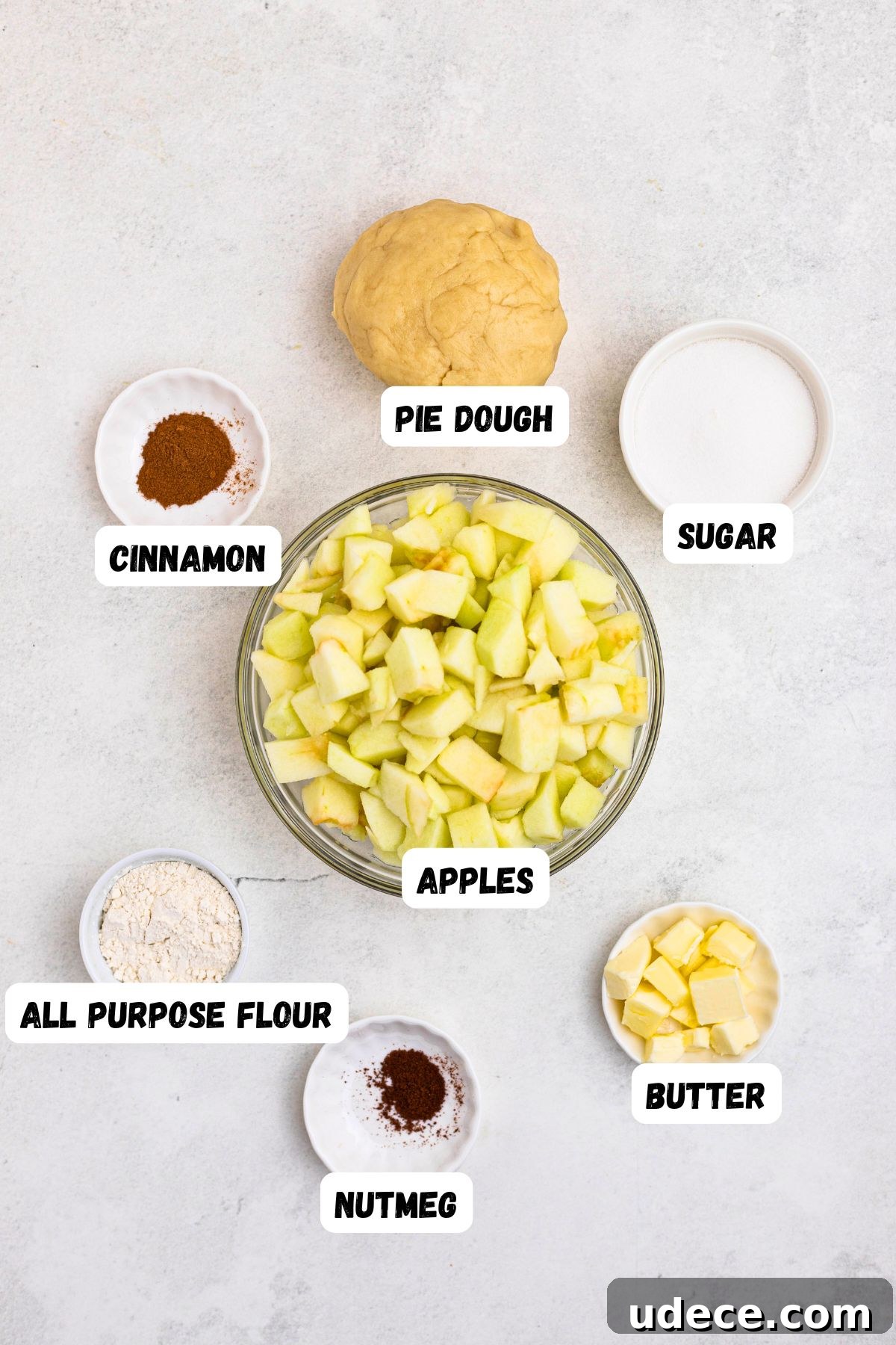Classic Homemade Apple Pie Recipe for Perfect Crust and Filling 3 Ingredients needed to make apple pie, measured into small bowls, on a white marble table.
