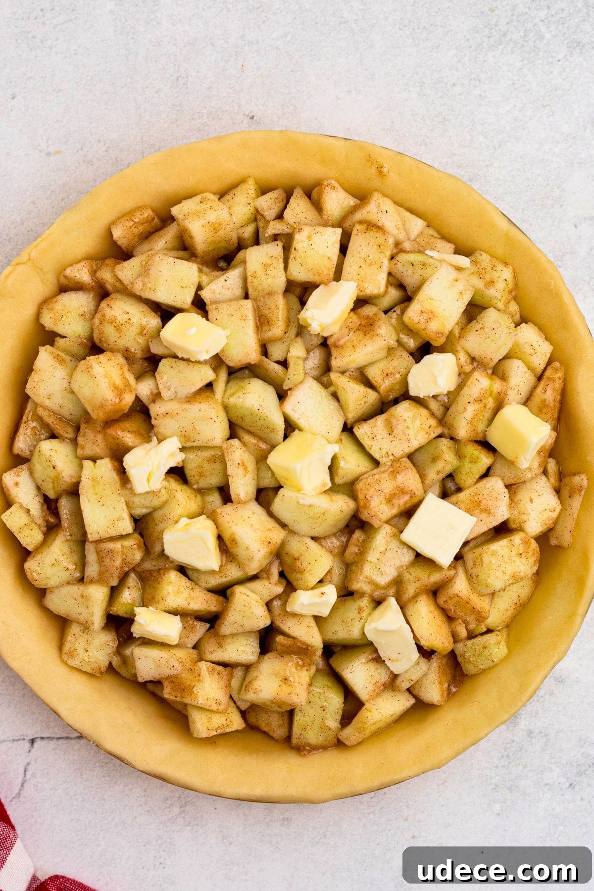 Classic Homemade Apple Pie Recipe for Perfect Crust and Filling 6 Bottom pie crust filled with apple pieces tossed in flour and seasonings, and cubes of butter.