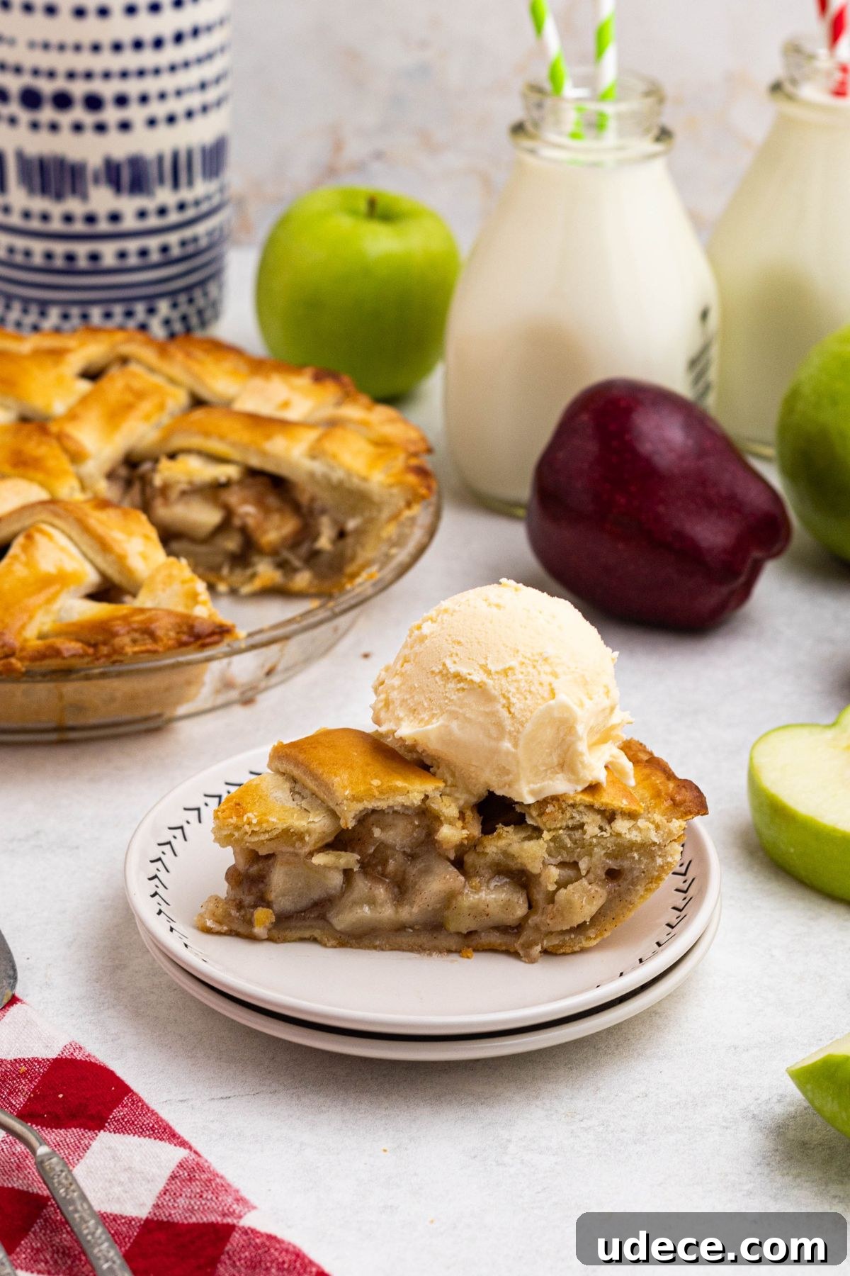 Classic Homemade Apple Pie Recipe for Perfect Crust and Filling 10 A slice of pie on small white plate with a scoop of vanilla ice cream on top.
