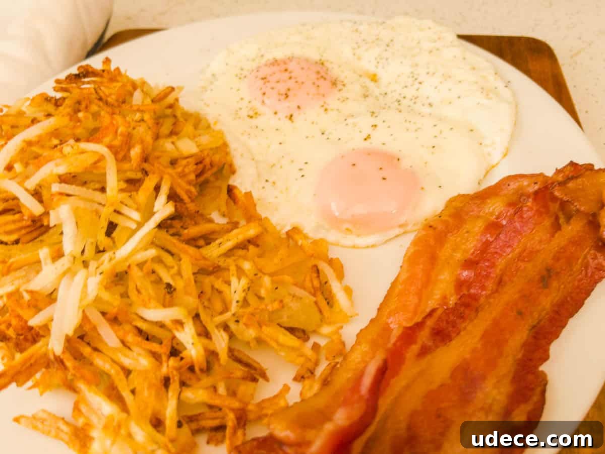 Crispy Air Fryer Hash Browns Ready in 15 Minutes 6 Hash browns eggs and bacon on a plate for breakfast