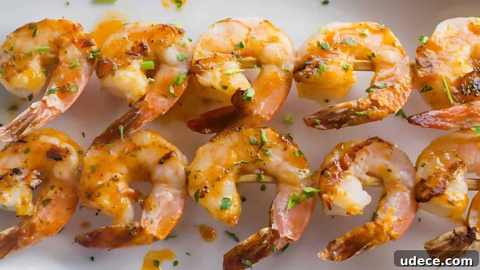 28 Seafood Dinners for Two That Deliver Restaurant-Quality Flavor 15 Grilled shrimp skewers garnished with chopped herbs, served on a white plate, with a light drizzle of sauce.