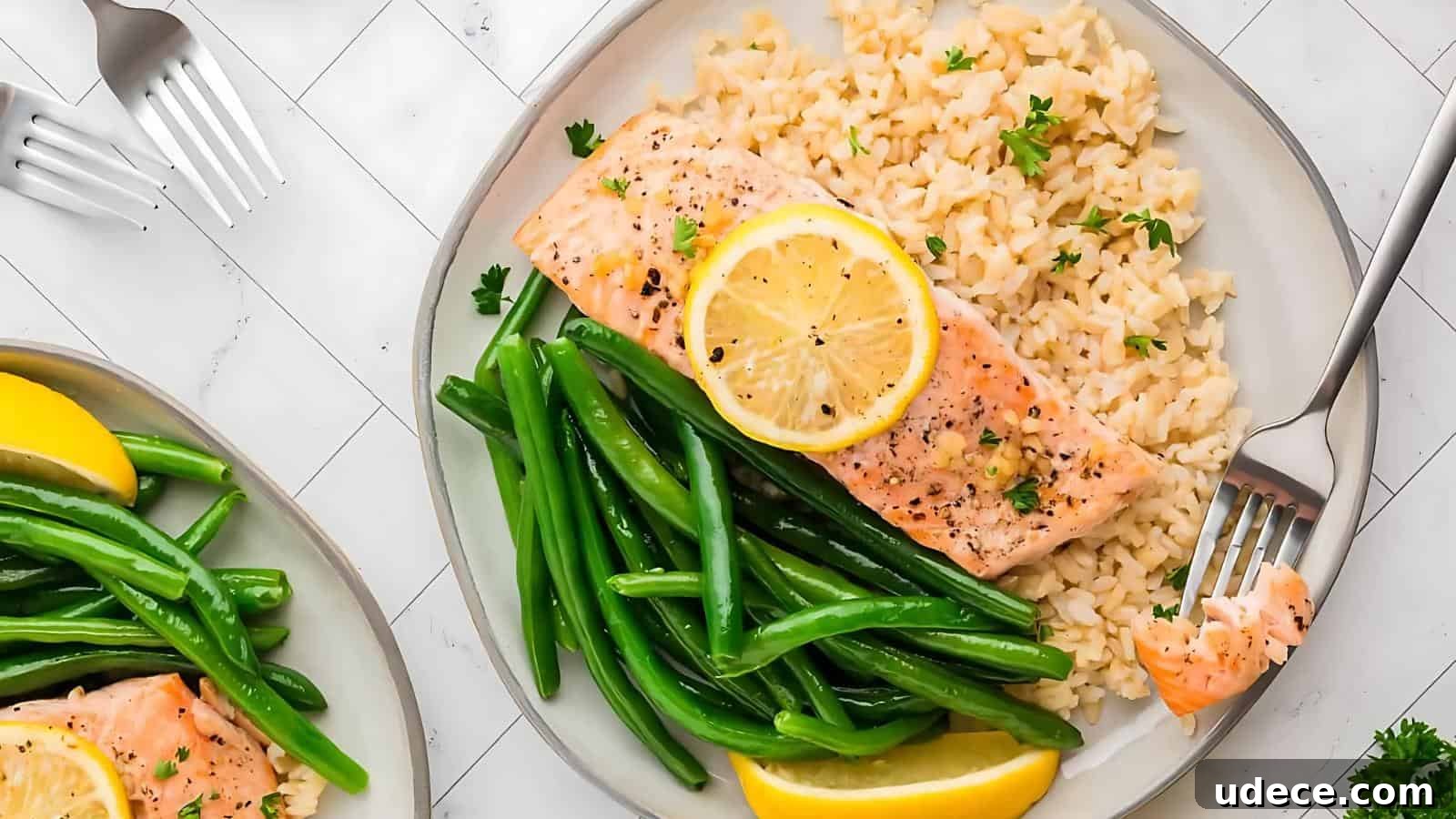 28 Seafood Dinners for Two That Deliver Restaurant-Quality Flavor 16 Plate with baked salmon topped with lemon slice, served with green beans and brown rice.