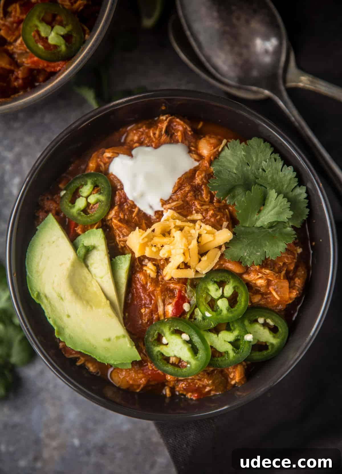 Smoked Chicken Chili Recipe: Hearty Texas-Style Slow-Smoked Chili 4 A bowl of easy smoked chicken chili topped with avocado, cheese, and jalapeño