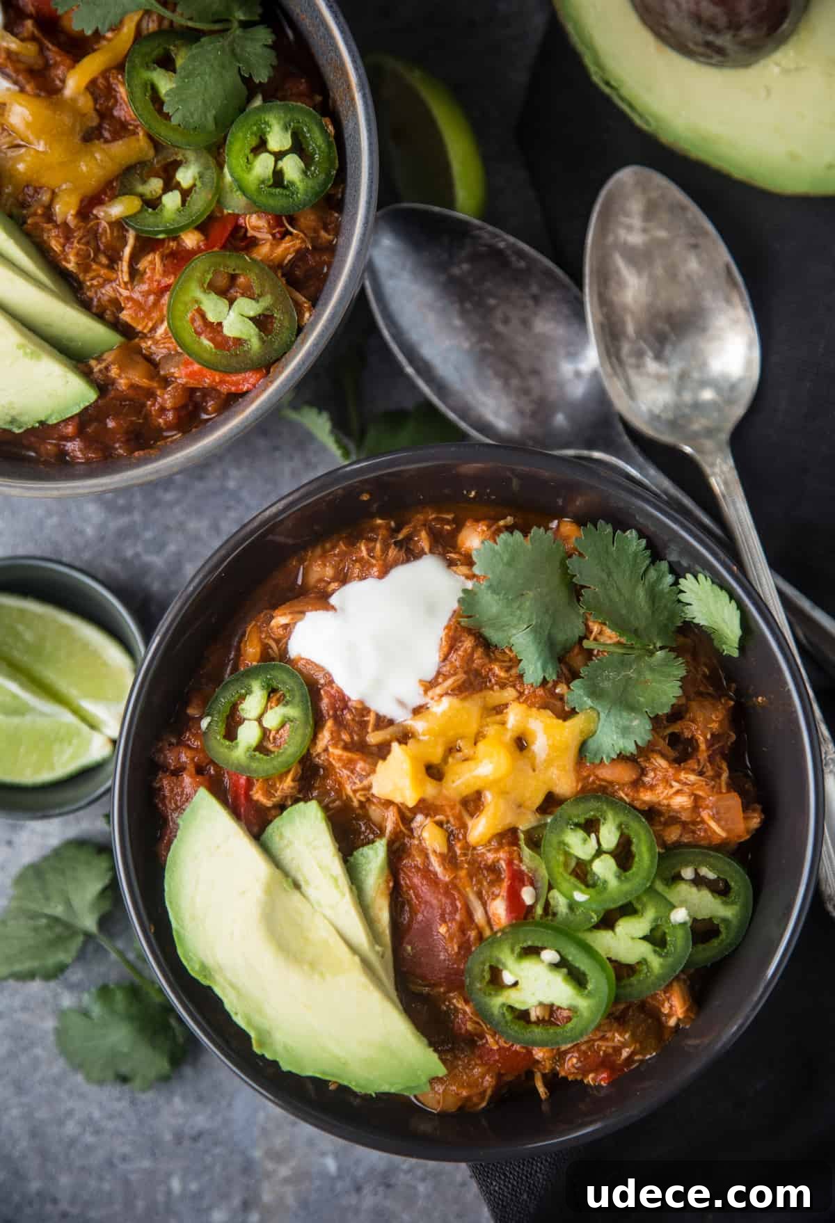 Smoked Chicken Chili Recipe: Hearty Texas-Style Slow-Smoked Chili 7 Two bowls full of smoked chicken chili topped with chili toppings