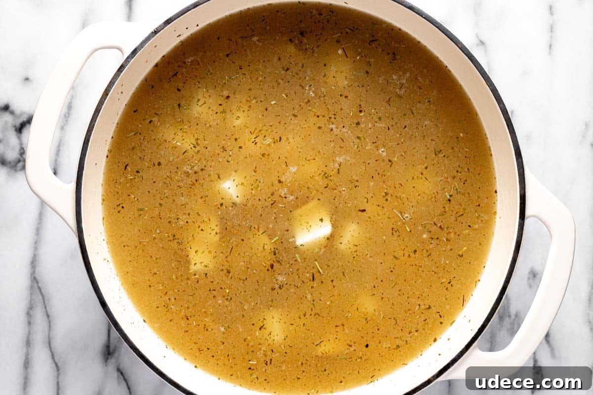 Large pot filled with ingredients to make loaded baked potato soup. 