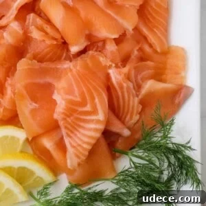 Homemade Gravlax: Simple Cured Salmon with Dill and Citrus 15 Close up of gravlax on a white platter with dill and lemons.