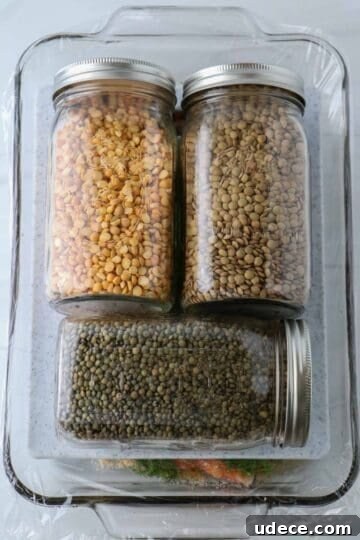 Homemade Gravlax: Simple Cured Salmon with Dill and Citrus 8 Salmon in a glass dish covered with a cutting board and three jars of beans.