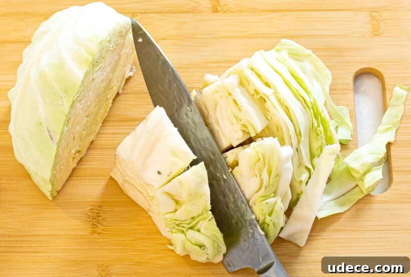 Garlic Butter Sautéed Cabbage Recipe for Quick Weeknight Sides 4 A head of cabbage being chopped on a wooden cutting board.