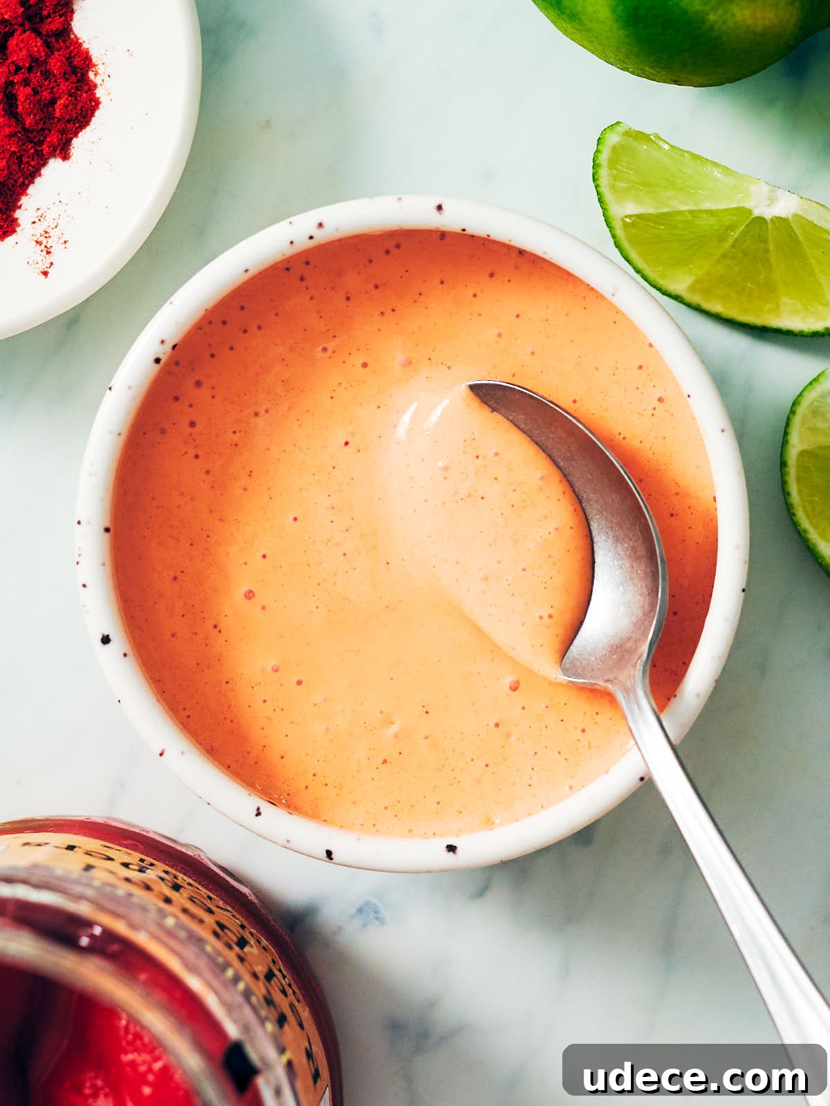 Smoky Roasted Red Pepper Crema Recipe 2 Roasted Red Pepper Crema in a bowl with a spoon.